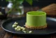 Tortas su „Matcha“ arbata, papuoštas baltojo šokolado drožlėmis