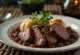 Tamsus jautienos kepsnys Sauerbraten su tirštu padažu lėkštėje