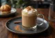 Frappe kava su cinamonu ir mėtomis, papuošta plakta grietinėle ir cinamono lazdele
