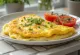 Tofu omletas, iškeptas iki auksinės spalvos, patiektas su šviežiais svogūnų laiškais.
